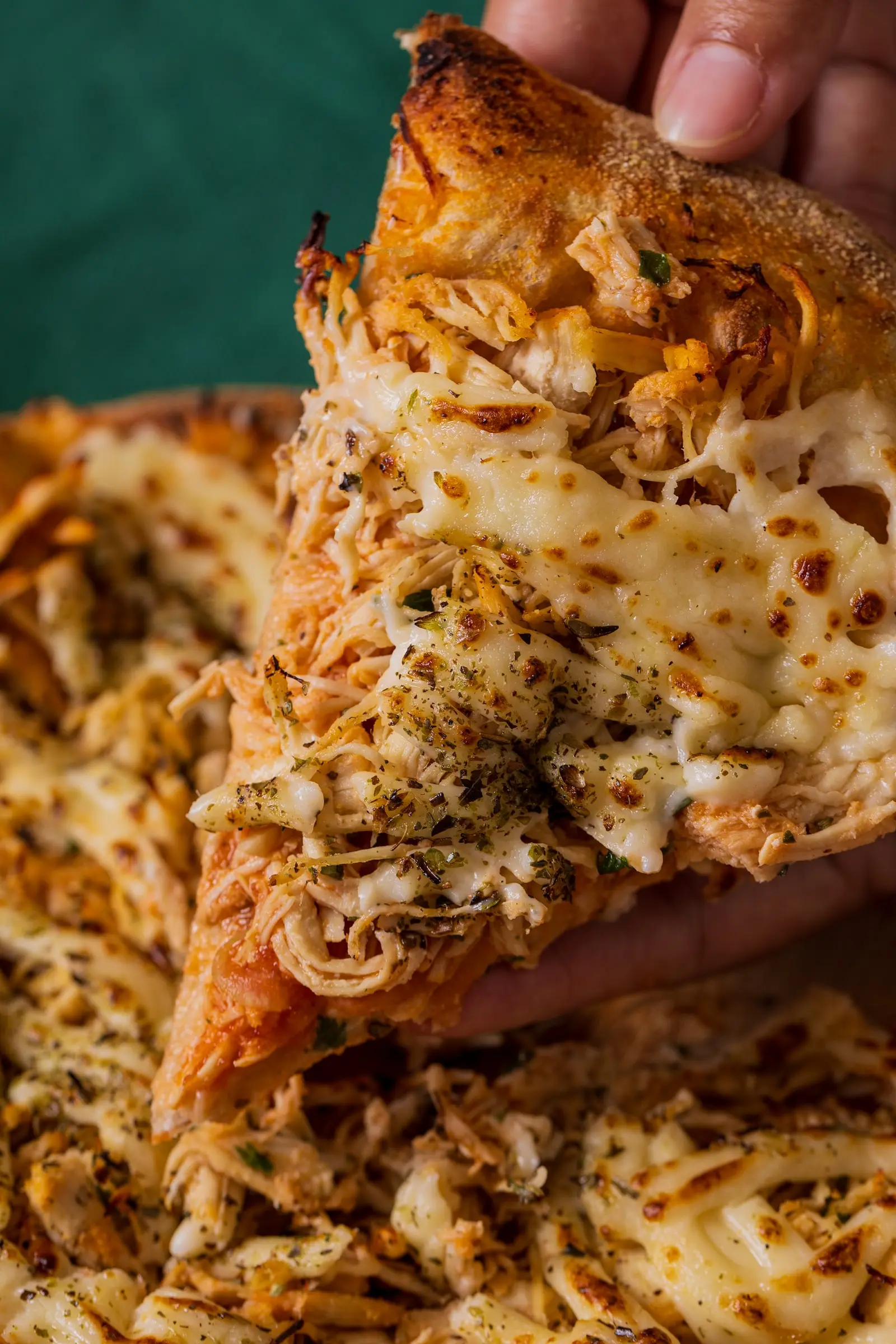 Fatia de pizza de frango com catupiry sendo servida